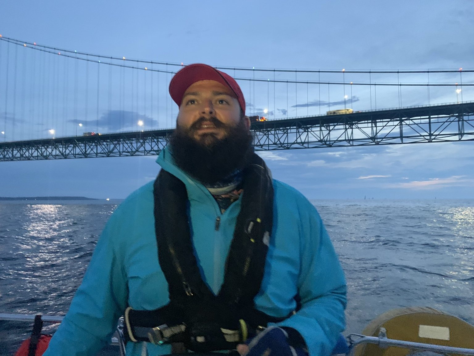 Dan Finholt aboard a sailboat beneath the Mackinac Bridge